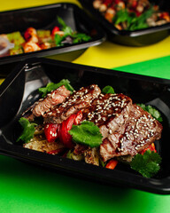 Healthy lunch at the workplace. Pick up food in black containers with cutlery