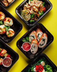 Healthy lunch at the workplace. Pick up food in black containers with cutlery