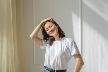 a young Asian woman with a square hairstyle with black hair and a white T-shirt, jeans. portrait of a happy positive girl
