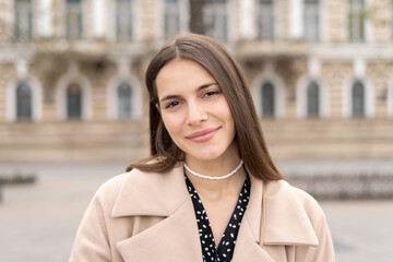 Portrait of a cheerful business woman with a cute smile looking in the camera standing in the park 