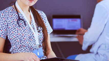 A medical team of doctors, man and woman,standing in office