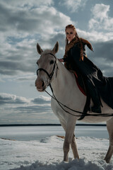 Obraz premium Young viking woman with red hairs ride a horse. Dramatic light. Role-playing game