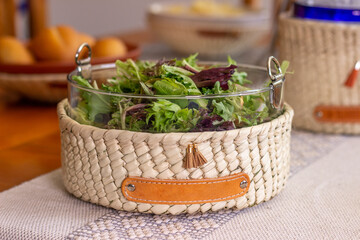 Obraz premium A lettuce salad served over the dining room in a basket made of palm leaves. Cansata weaved in an artisanal way, tradition in Latin America.