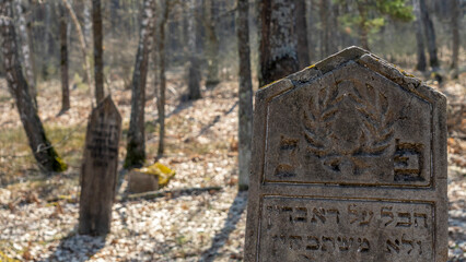 Unique Wooden Jewish matzevah. Jewish Tombstone. Old jewish cemetery in the forest.