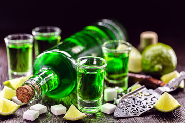 doses of absinthe with brown sugar cubes. distillate of absinthe in a glass and lemon, stainless...