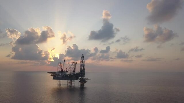 Aerial view of the jack up rig shot during sunset time. Fly around the jack up rig with a drone.
