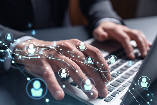 Hands of hr specialist is typing the keyboard in the internet to find the best candidates to create international network in recruitment process. Formal wear. Social media hologram icons.
