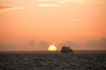 Navio no pôr-do-sol, na foz do rio Amazonas, em Macapá, Amazônia, Brasil.