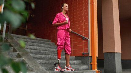 Young woman with leg prosthesis in sports clothing