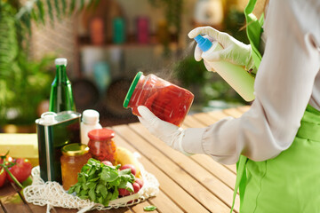 Woman in kitchen disinfecting groceries after supermarket