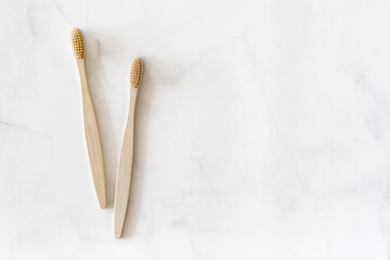 Composition with biodegradable bamboo toothbrushes on marble background. Sustainable, zero waste, plastic free, lifestyle concept. Eco-friendly oral hygiene accessories.Flat lay, top view, copy space.