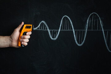 A man's hand holding and pointing electronic non-contact infrared thermometer. measuring...
