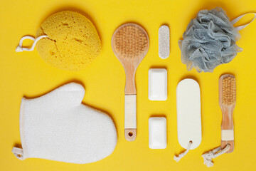 top view of bath accessories. Various personal hygiene and spa items arranged on the yellow background