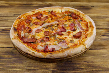 Delicious fresh pizza with sausage, mushrooms and cheese on a wooden table