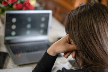 Stressed Woman studying at home while use notebook for remote schooling video call,covid-19 pandemic