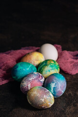 multi-colored Easter eggs of blue tones on a pink cloth background. Easter eggs in low key