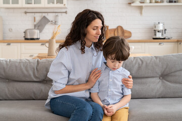 Mother trying to distract upset kid. Young mom engaging depressed offended son in bad mood by hug....