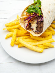 french fries and a shawarma served on a white plate