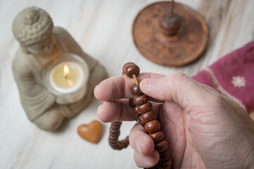 Using Prayer Beads or a Mala to count mantra recitations during meditation - obrazy, fototapety, plakaty