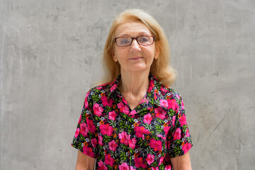 Portrait of a senior woman outdoors during summer wearing colorful shirt and eyeglasses