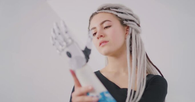 The girl is looking at bionic prosthesis   Bionics Cybernetic Robotic-arm Hand prosthesis