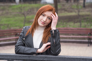 Portrait of a beautiful and positive redhead woman with clothes in grunge style. Posing while walking