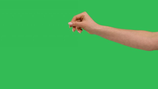 Close up side view of beautiful outstretched female hand with a sprinkling gesture isolated on green screen chroma key background. Chef hand adds pinch salt or spice to the dish. Slow motion.