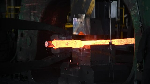 Forging a large hot metal billet with an industrial forging press