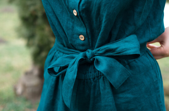 Close Up Of Emerald Green Linen Jumpsuit Garment Belt With Coconut Buttons. Concept: Sustainable Timeless Fashion