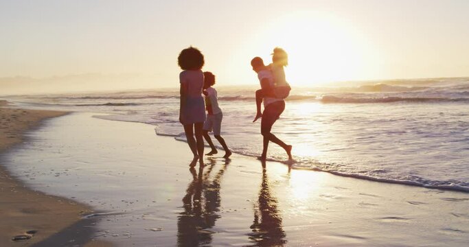African american family having fun together during sunset on the beach