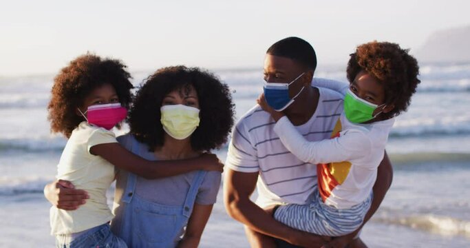 Portrait Of African American Family Wearing Face Masks At The Beach