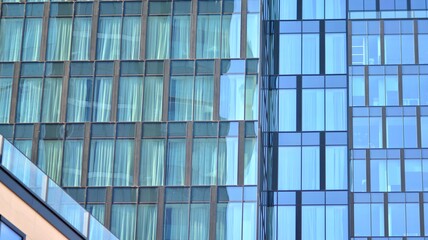 The glazed facade of an office building with reflected sky. Modern architecture buildings exterior background. Clouds sky reflection.