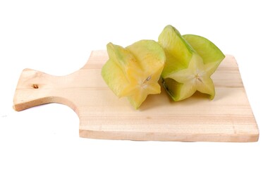 Star fruit slices on a wooden cutting board isolated on a white background