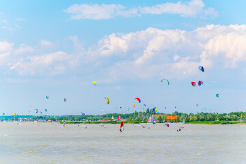 Young people are kite surfing on the neusiedlersee lake in Austria near Podersdorf am See town. - Powered by Adobe