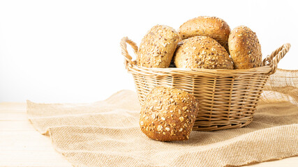 Rye bread isolated. Bakery with crusty loaves and crumbs. Fresh loaf of rustic traditional bread with wheat grain ear or spike plant on natural cotton background. Bio ingredients, healthy with seeds.