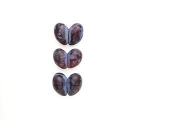 Heart-shaped prunes or double plums. Ugly fruits on light background with copy space