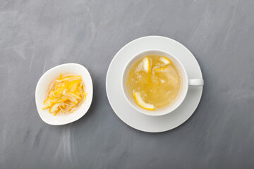 Yujacha (yuja tea or yuzu tea) - Korean citrus tea, made by mixing hot water with yuja marmalade. Grey background, top view