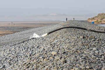 Large pipe drains overflow water from a flooded area