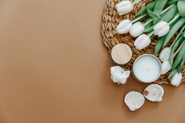 Still life cadges with tulips and candles on brown background.