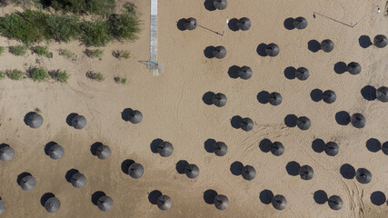 Top view straw umbrellas on the beach on a sunny day. The concept of rest and relaxation.