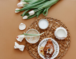 Flat Lay Morning coffee for mother day, 8 march. Coffee Cup, croissant on brown background. Fresh white tulips. Spring concept, still life composition