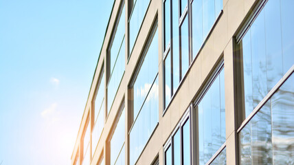 Obraz premium A fragment of modern architecture, walls and glass. Windows and balconies of a residential building against a blue sky. Detail of New luxury house and home complex. Part of city real estate property a