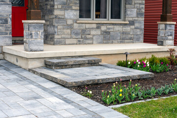 Luxury residential landscaping and front garden shows a precast paver landing, steps and driveway...