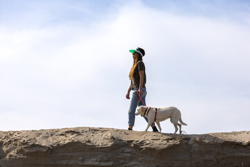 young woman walking with her dog in desert