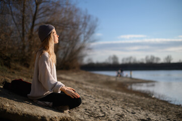Practice of meditation and interaction with nature. Girl near river