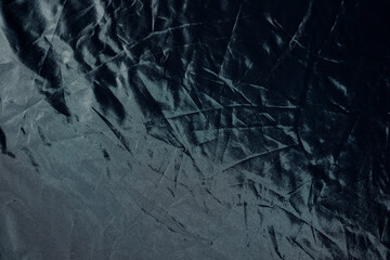 Black fabric foil texture of silver mirror color. Copy space.