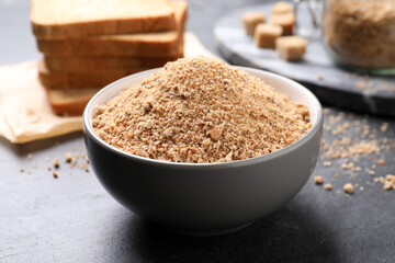 Fresh breadcrumbs in bowl on black table