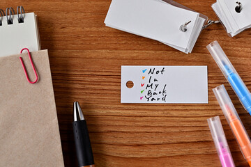 There is word book and colored pens with the word Not In My Back Yard written on it with notebook and envelope