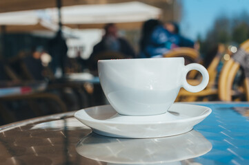 A cup of coffee on a table in a coffee shop.
