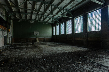 Dark creepy ruined gymnasium in abandoned school